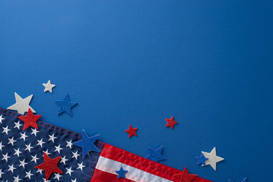 Fourth of July festivities concept. From top view, showcase symbolic party props like glittering stars and national flag, all against blue backdrop with an empty space for text or promotional content