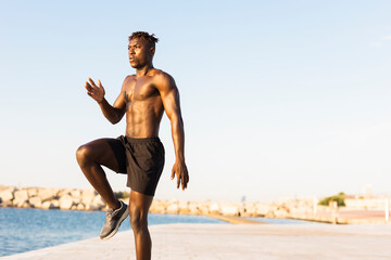 Fitness training outdoors. Handsome African man doing exercises outside. Muscular man training..