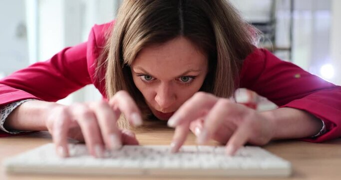 Woman angry face at table with computer and keyboard. Negative comments and cyberbullying on Internet