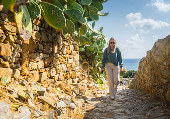 Attractive woman walking through Mediterranean scenery, sea view, Crete Greece