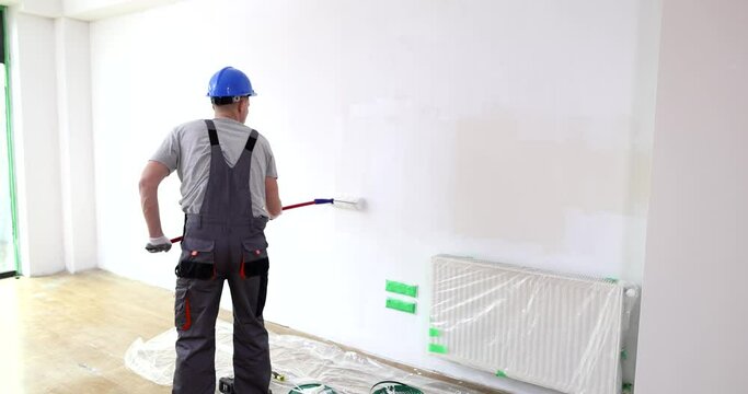 Painting walls with white paint using roller. Wall painting services for your home or office