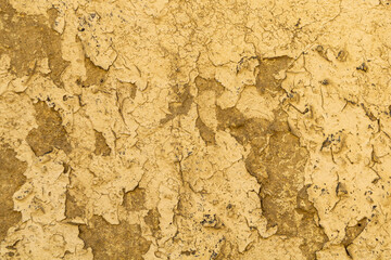 Yellow weathered plastered wall with crack as texture, pattern, background