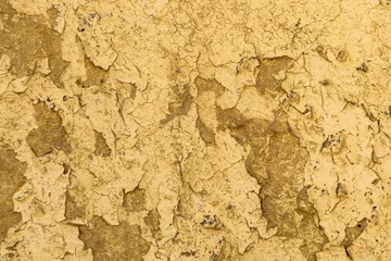 Fotobehang Verweerde muur Yellow weathered plastered wall with crack as texture, pattern, background