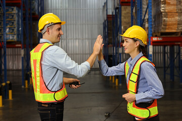Happy smiling teamwork with hardhats and reflective jackets give high five celebrate successful together completed deal commitment at retail warehouse logistics, distribution center, success concept