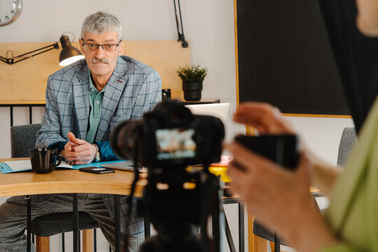 Woman filming male colleague holding online class