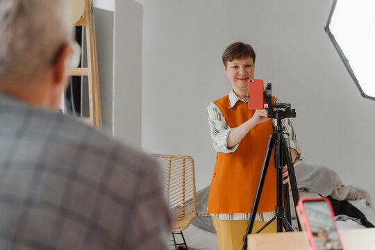 Woman filming male colleague holding online class
