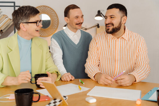 Colleagues laugh and talk to each other at the studio