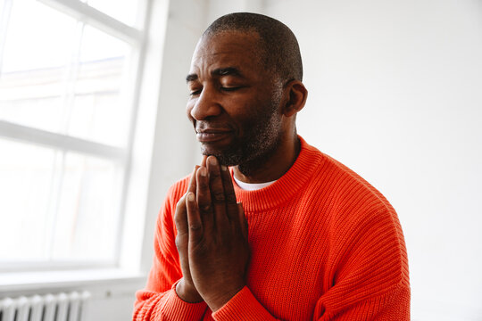 Mature man with hands clasped at home