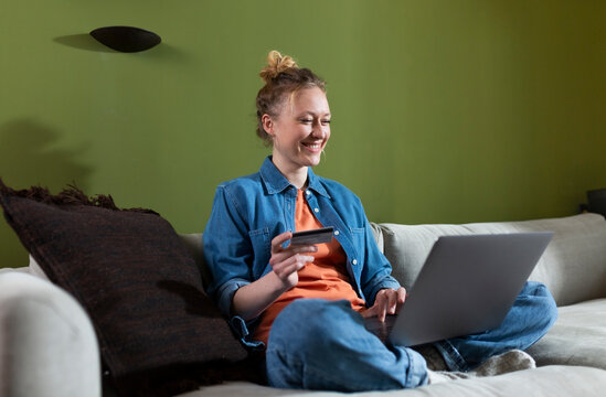 Happy young woman doing online shopping at home