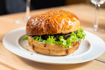 traditional classic burger served on white plate over black background. Meat hamburger flat lay. Beef hamburger. Organic hamburger. Junk food, fast food concept. Top view copy space