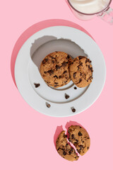Plate with chocolate chip cookies isolated on pink background
