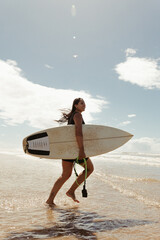 woman with her surfboard on the beach