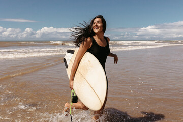 woman with her surfboard on the beach