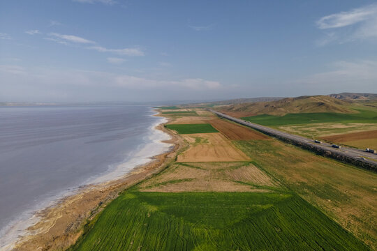 Aerial view of a road driving along the Tuz Golu (Lake Tuz), one of the largest hyper saline lake in the world, Central Anatolia Region, Turkey.