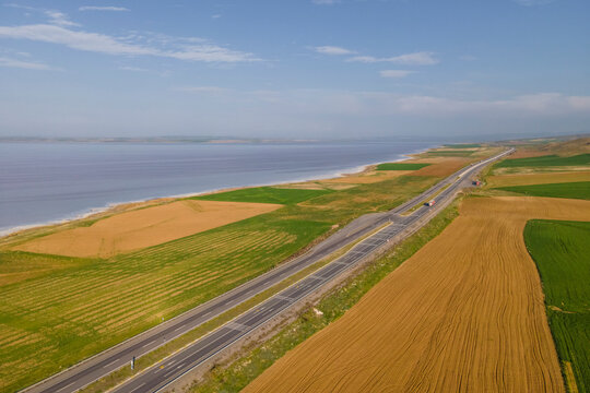 Aerial view of a road driving along the Tuz Golu (Lake Tuz), one of the largest hyper saline lake in the world, Central Anatolia Region, Turkey.