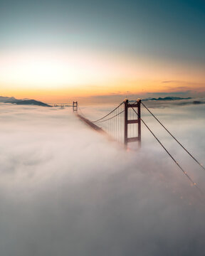 Aerial view of Tsing Ma Bridge at sunset with low clouds in Hong Kong Island, Hong Kong, China.