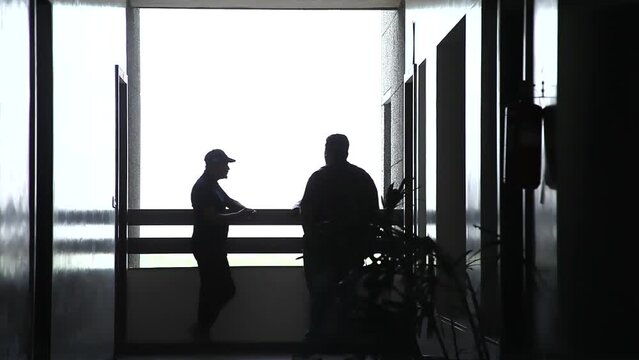 People are talking on the railing of building Floor in Night - Gujarat, India 29 April 2023

Business persons talking and walking on the floor with White Background.
Elevator Black and White scene