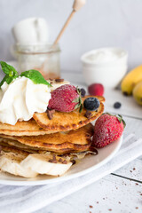 Pancakes with fresh berries and cream. Breakfast. On a wooden background