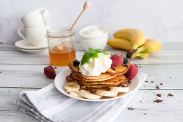 Pancakes with fresh berries and cream. Breakfast. On a wooden background