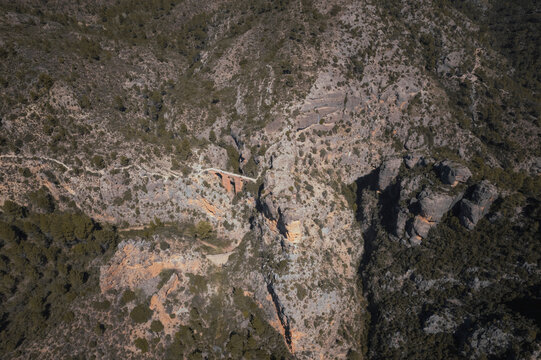 Aerial view of the Roman aqueduct of Pena Cortada surrounded by monumental rocks and plants, Calles, Valencia, Spain.