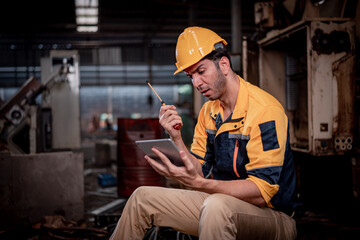 Worker wearing uniform sitting in factory plantation posing feel tried and serious with work ,he...