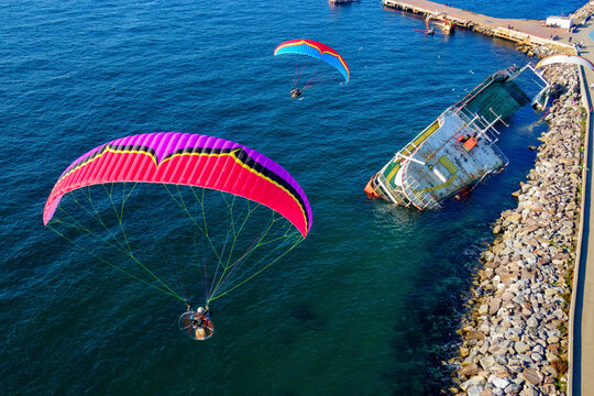 Aerial view of two paramotors flying over a shipwreck in Maltepe district on the Marmara Sea coast of the Asian side of Istanbul, Turkey.