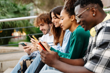 Young African American woman using cell phone together with multiracial group of friends