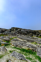 Fototapeta na wymiar Weathered Mountain Hillside With Rocky Outcrops And Grass