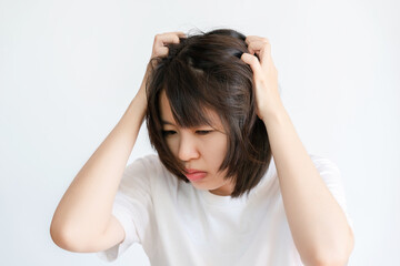 Portrait of Asian woman scratching her head on white background.