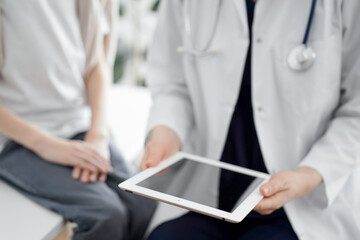 Doctor and child patient. The doctor is using tablet computer and is ready to examine the boy. The concept of ideal health in medicine.