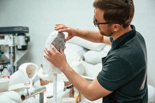 Working with raw materal for prosthesis indoors. Technician is busy