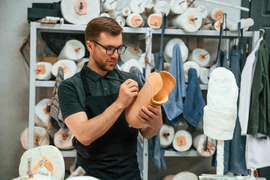 Marks the line with a marker. Technician working with prosthesis part in modern laboratory