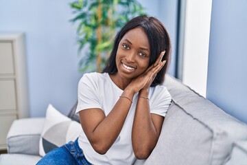 Young african american woman smiling confident doing sleeping gesture with hands at home