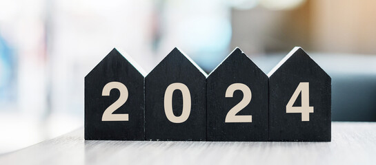 2024 Happy New Year with wooden Home model on table office. New House, Financial, Property...