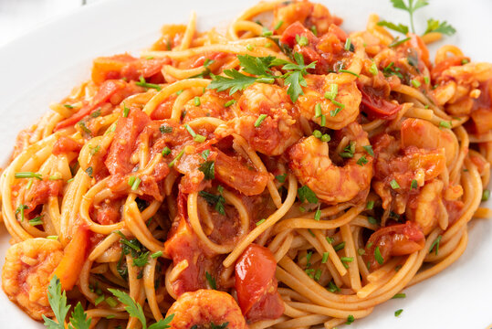 Vassoio di deliziosi spaghetti conditi con sugo di gamberi, cibo italiano 