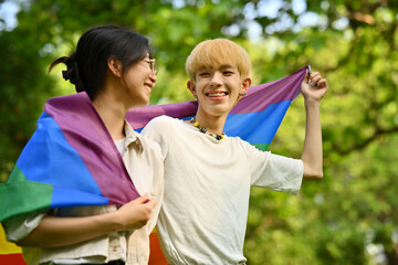 Obraz premium Image of young people with LGBTQ pride flag standing outdoor, supporting LGBTQ community and equality social