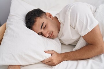 Fototapeta na wymiar Young hispanic man lying on bed sleeping at bedroom