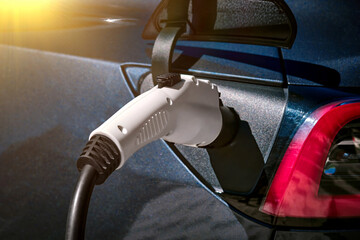 Close-up of a black electric car charging in a street parking.