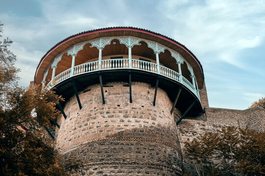 An old stone tower with a beautiful wooden balcony in the historical part of the city. Royal balcony in the palace of Queen Darijan: Tbilisi, Georgia - May 24, 2023.