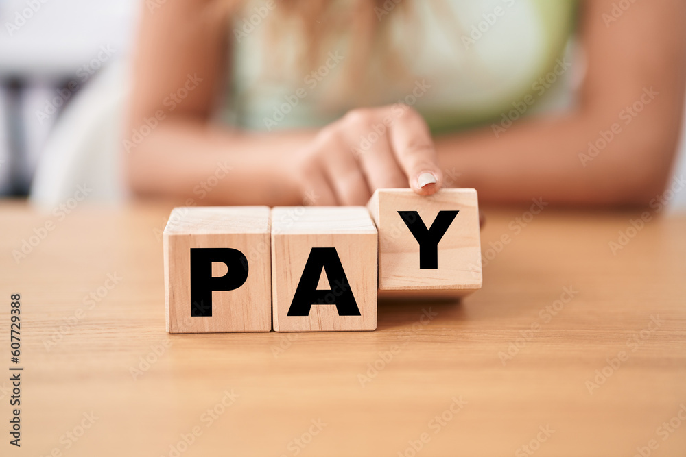 Wall mural young woman holding cubes with pay word on the table