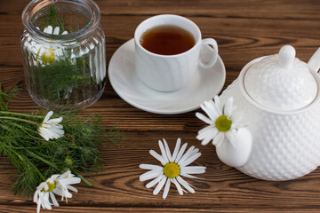 A cup with a hot morning drink and a bouquet of flowers. The concept of rustic style