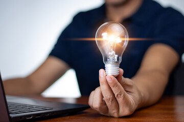 Obraz na płótnie Canvas Human hand holding a light bulb, creative concept, innovation and inspiration. creative concept with glowing light bulbs, concept