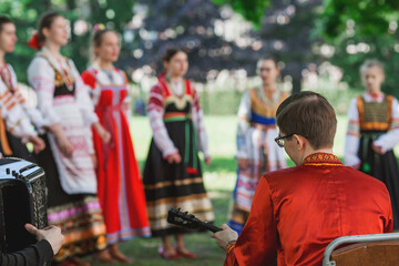 Russian folk traditions. Folk festivals. Children in beautiful Russian traditional outfits sing songs, dance and lead a round dance in Tsaritsyno Park. National Russian clothes. 