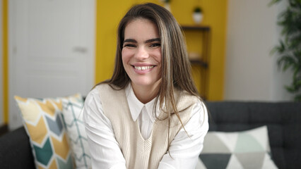 Young beautiful hispanic woman smiling confident sitting at home