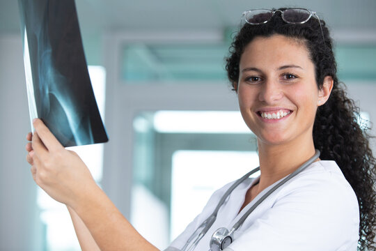 smiling female doctor studying x-ray