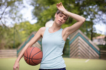 tired young woman after playing basketball
