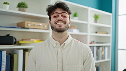 Young hispanic man student smiling confident standing at library university