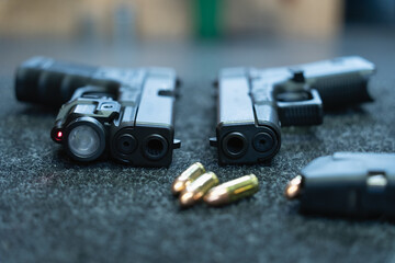 Obraz premium Firearms in the shooting range. Pistol with flashlight, laser sight and 9mm ammo.