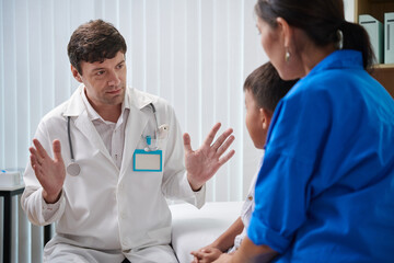 Friendly pediatrician talking to sick little boy