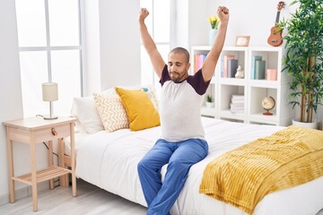 Fototapeta na wymiar Young latin man waking up stretching arms at bedroom